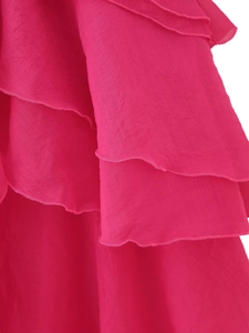 Close-up detail of tiered ruffles and delicate hem stitching on rose red chiffon skirt