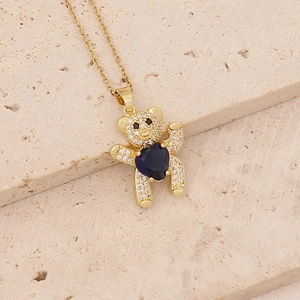 Detailed shot of teddy bear necklace with heart-shaped dark blue gem on stone