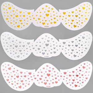 Detailed view of heart-patterned face tattoo stickers in gold, silver, and red colors