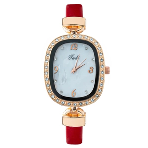 Montre dorée élégante pour femme avec lunette en strass et bracelet en cuir rouge