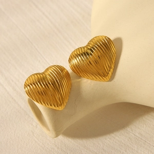 Macro detail of 18k gold plated stainless steel heart earrings with vertical stripes