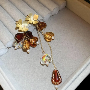 Détail de boucles d'oreilles vintage fleurs et cœurs à pompons sur du velours