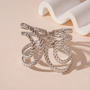 Close-up of silver hollow cable twisted cuff bracelet with intricate metal textures