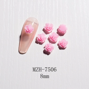 Macro shot of 8mm pink resin 3D rose nail art charm on a nude fake nail display