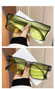 Detail view of translucent gray oversized sunglasses with vibrant yellow lenses and metal joints