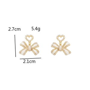 Detailed view of bow heart earrings with white pearls, size 2.7cm by 2.1cm and weight 5.4g