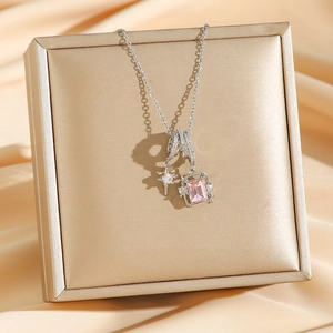 Collana con stella e gemma quadrata rosa su un astuccio dorato per gioielli