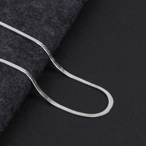 Macro shot of silver snake chain necklace showing flat structure and metallic gloss