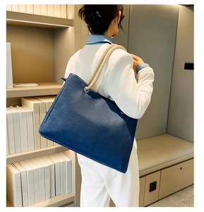 Blue large capacity canvas shoulder bag with thick beige rope handles on a model