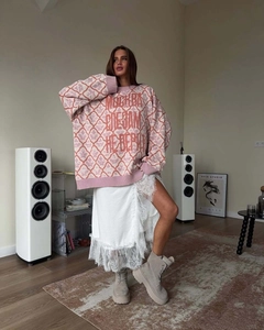 Detail of pink knitted sweater with Cyrillic text and white lace skirt styling