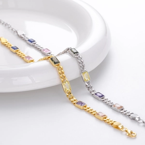 Dettaglio di bracciali a catena barbazzale in oro e argento con gemme quadrate colorate