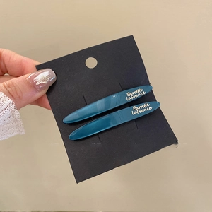 Close-up of cyan blue resin hair clips with pearlescent finish and Barrette LaFrance text
