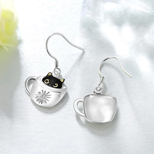 Macro detail of cat in coffee cup earrings showing enamel finish and silver metal back