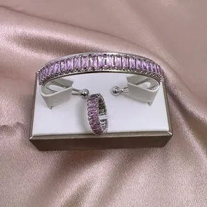 Detalle de set joyería de cristal rosa con piedras rectangulares sobre seda