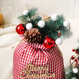 Red and white checkered Christmas drawstring gift bag with pine cones and wooden tag