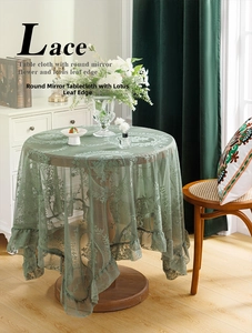 Macro detail of sage green lace tablecloth featuring floral embroidery and ruffled edges