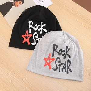 Platliggende zwarte en grijze gebreide mutsen met Rock Star print op houten achtergrond