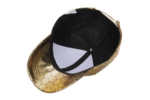 Detail of the golden hexagonal mesh texture and adjustable metal buckle on a baseball cap
