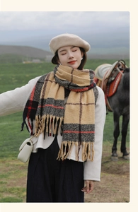 Close-up of beige plaid scarf with fringe detail, soft thick knit wool texture
