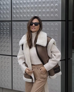 Detail of Y2K style faux fur and leather vest in deep khaki with sherpa lining