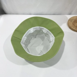 Grass green cotton bucket hat with white lining shown from a top-down interior perspective