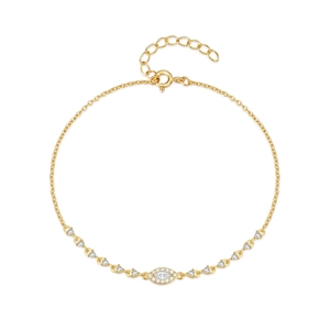 Macro detail of gold devil's eye tennis bracelet with marquise zircon and fine chain link