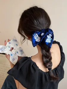 Close-up of embroidered satin scrunchies featuring jellyfish and seashell patterns