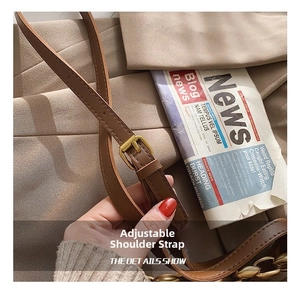 Detail of adjustable brown leather strap with gold buckle and fine stitching