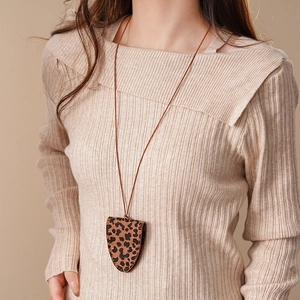 Detailed close-up of a leopard print leather pouch necklace worn as a fashion accessory
