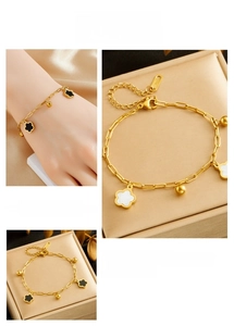 Detail of gold plated stainless steel bracelet with black and white clover charms