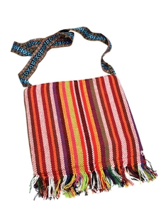 Detail of bohemian woven crossbody bag featuring colorful stripes and fringe tassels
