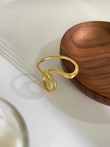 Macro view of geometric multi-layer wrapped 18K gold plated titanium ring with glossy finish