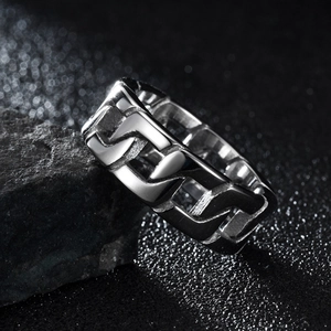 Primo piano di un anello in acciaio al titanio argento con catena cubana per uomo hip hop.