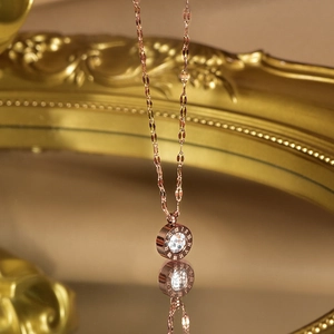Macro shot of rose gold necklace with Roman numeral ring pendant and clear gemstone