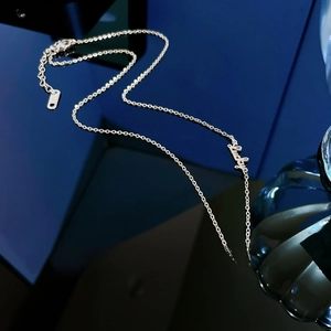 Gros plan du pendentif étoile argenté gravé Lucky Star sur une chaîne fine
