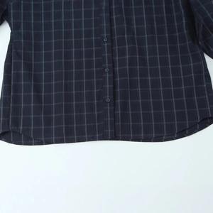 Plaid long sleeve poplin shirt for women featuring a dark checkered pattern and curved hem