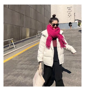 Close-up of a soft white puffer jacket paired with a vibrant rose red knitted scarf