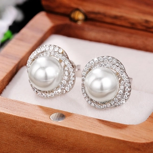 Detail of tear-shaped pearl earrings with zircon flower design in a wooden gift box