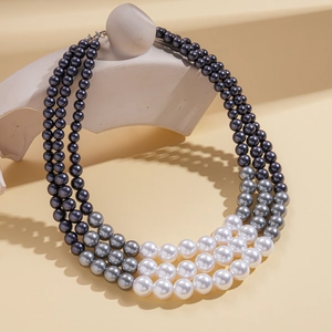 Detailed close-up of a three-layer gradient pearl necklace in black, grey and white