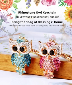 Close-up of owl keychains with colorful rhinestones on a wooden display stand