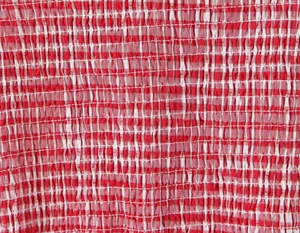 Close-up of red and white plaid fabric with smocked elastic texture on a sweet dress