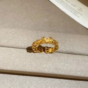 Close-up of a 24K gold plated bow-shaped open ring displayed in a jewelry box slot