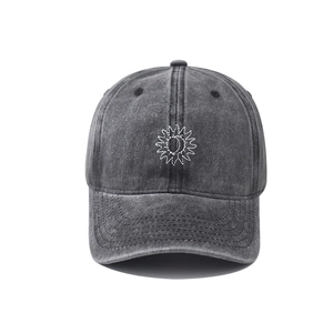 Detail view of embroidered sun and moon logo on washed vintage gray cotton baseball cap