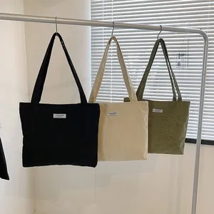 Three corduroy tote bags in black, beige and olive green with a Fashion label detail