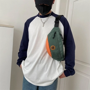 Men's green and orange oxford crossbody chest bag in a casual street style look