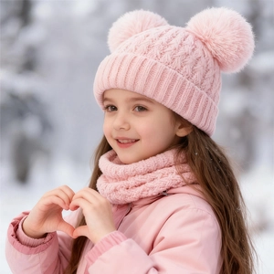 Close-up of pink knitted winter hat with double faux fur pom-poms and matching neck warmer