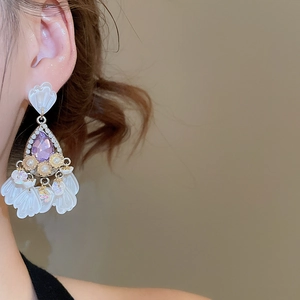 Detailed close-up of luxurious vintage flower drop earrings with purple crystals and petals