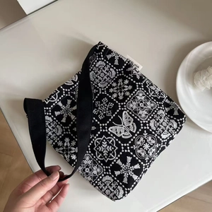 Black canvas tote bag with white butterfly embroidery and vintage floral patterns