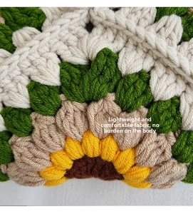 Close-up of hand-crocheted sunflower pattern with thick yarn texture on a beige shoulder bag