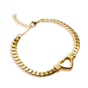 Detail shot of a golden heart Cuban link bracelet with lobster clasp on white background